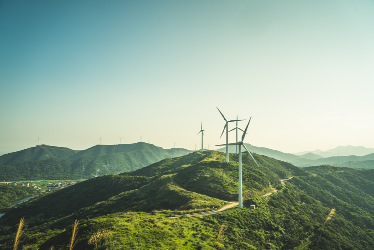 A group of windmills standing on a hill and generating energy.